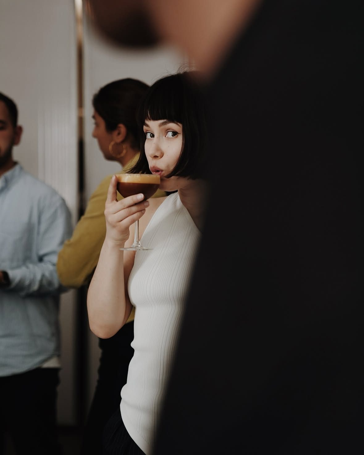A guest sipping an espresso martini at an event in the café