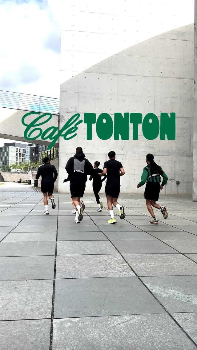 Runners crossing the plaza past a Café TONTON sign