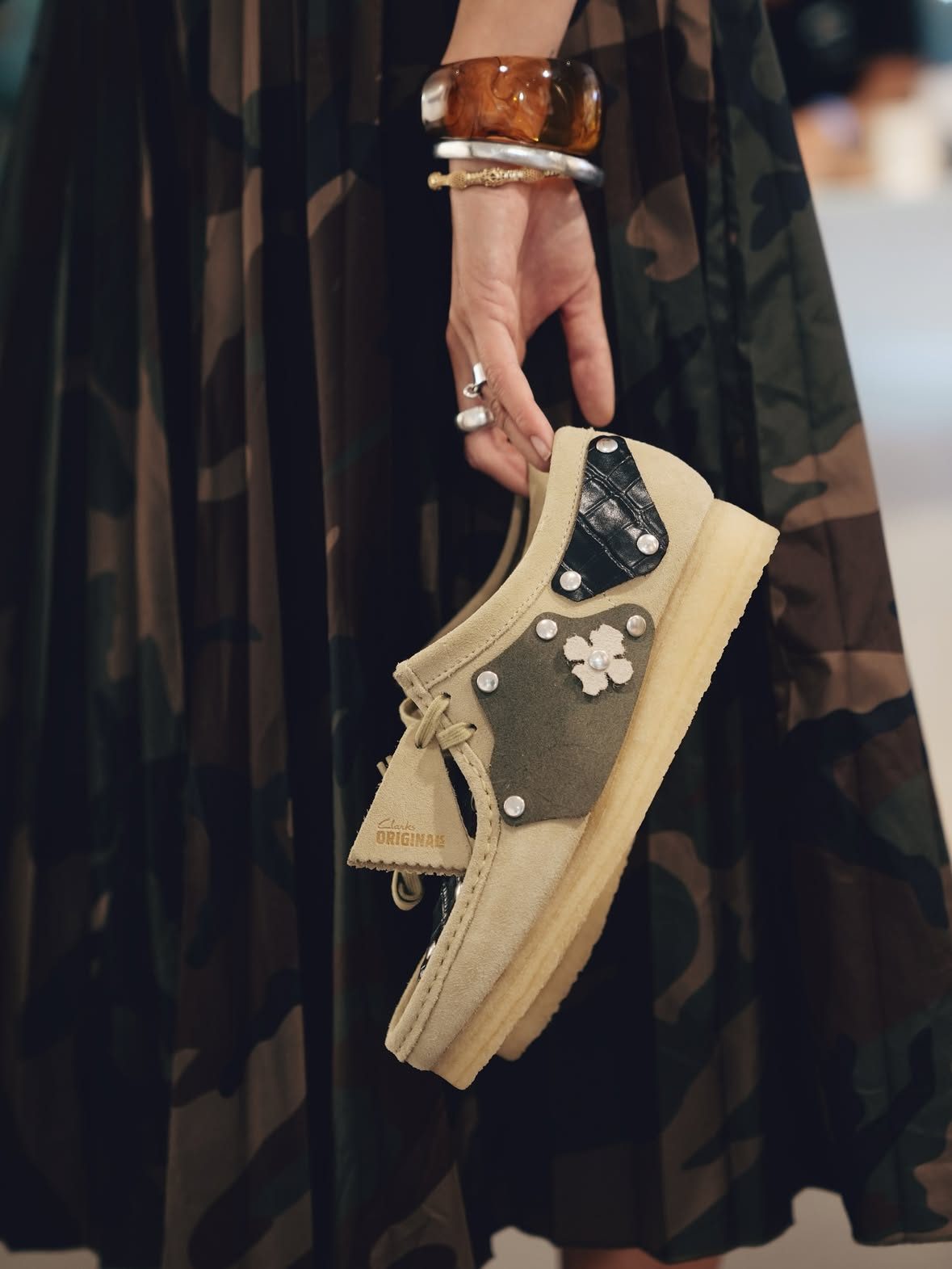 A hand holding a Clarks Originals shoe