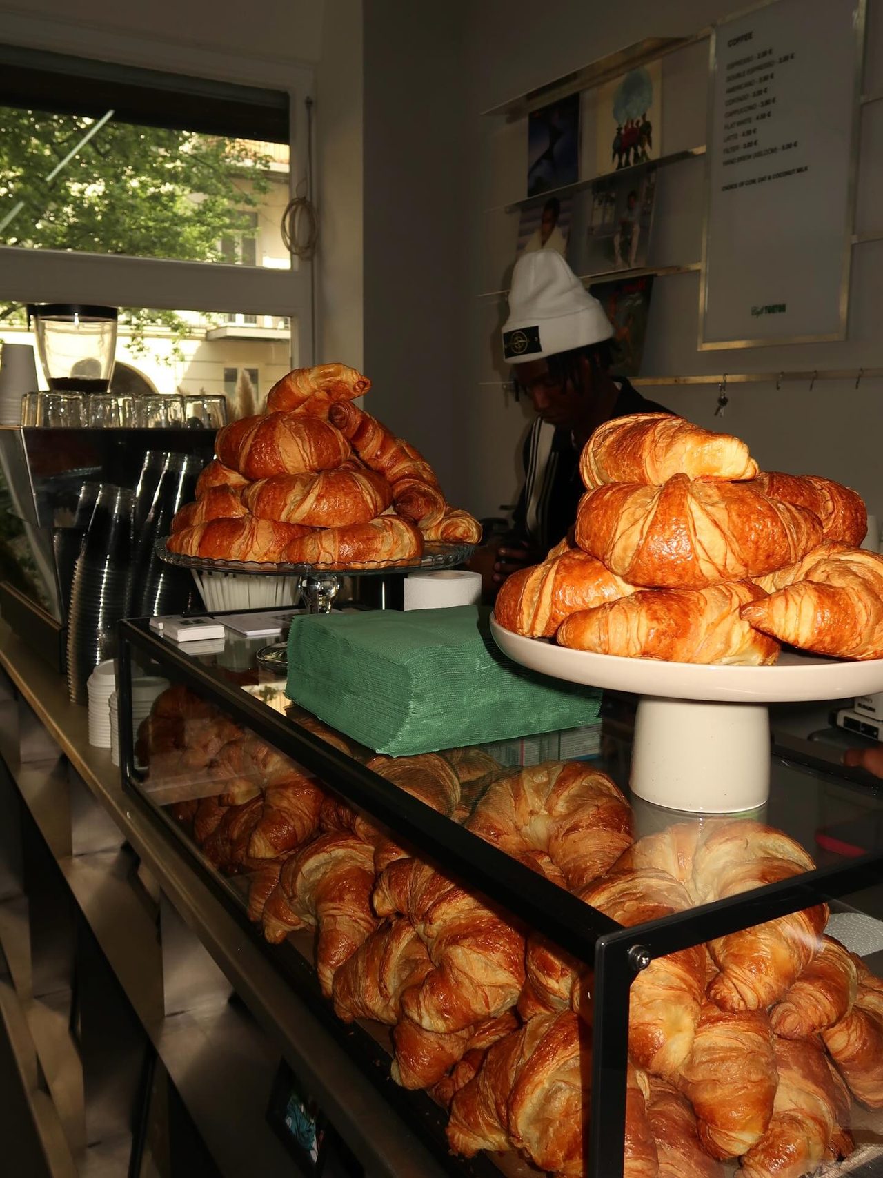 Croissants piled on two cake stands and in the glass counter at Café TonTon.